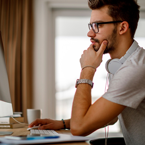 Homem sentado em frente ao computador fazendo Follow Up de leads.