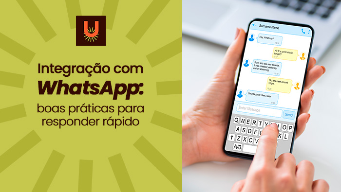 Mão segurando um smartphone com aplicativo de mensagens aberto, digitando conversa em tempo real sobre mesa de trabalho clara.