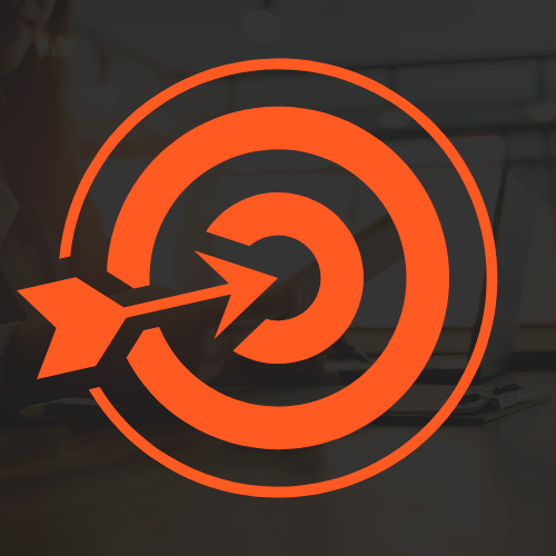 Ícone de alvo com flecha ao centro sobre fundo desfocado de ambiente de trabalho, representando foco, metas e resultados.