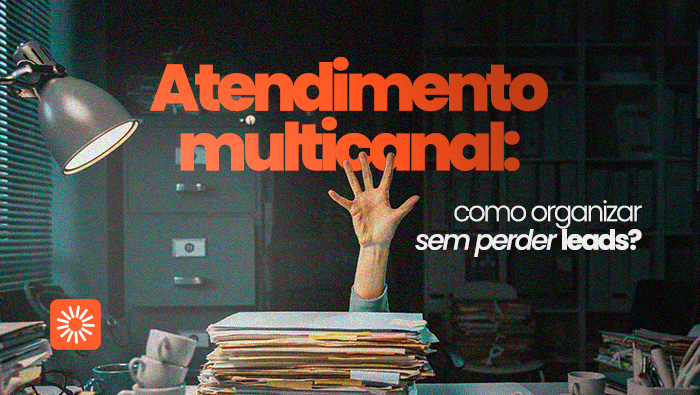 Mesa de escritório com pilhas de papéis e mão levantada ao fundo, representando sobrecarga e desorganização no trabalho.