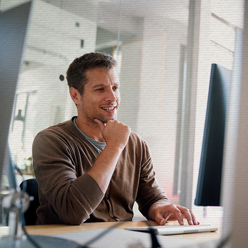 Homem trabalhando em computador no escritório, representando análise de dados, histórico de atendimento e gestão de relacionamento com clientes.