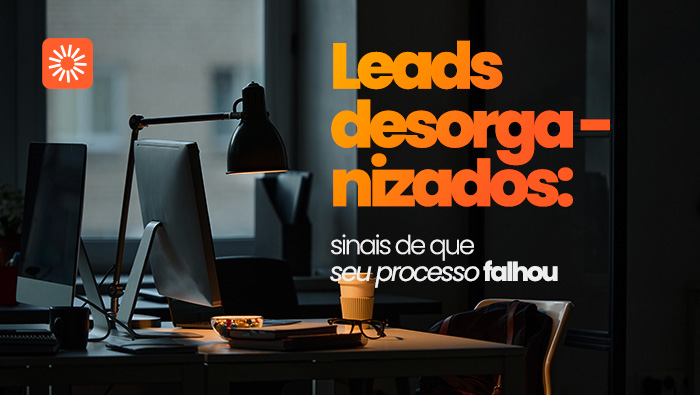 Mesa de escritório com computador e iluminação baixa, representando organização, rotina de trabalho e gestão de leads.