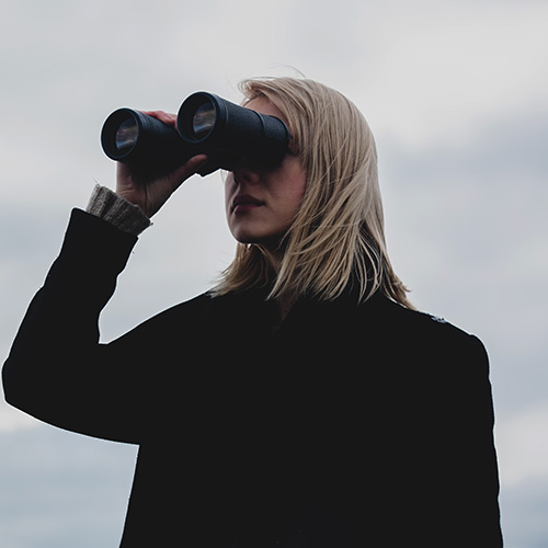 Pessoa observando com binóculos em busca de oportunidades